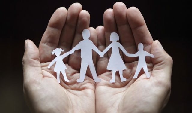 immagine due mani che accolgono l'immagine di una famiglia stilizzata